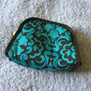 A Small teal and brown patterned makeup bag